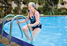 Senior woman getting out of an outdoor pool